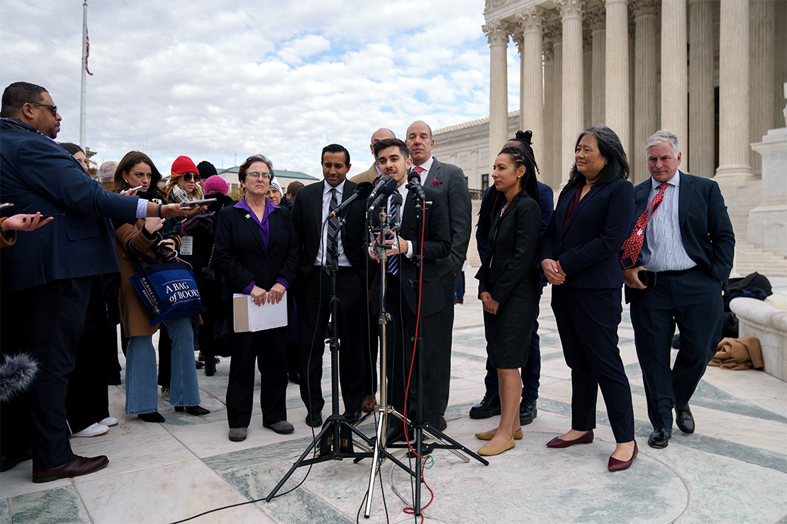 ACLU attorney Chase Strangio along with various other ACLU attorneys speak at a press conference right in front of the US Supreme Court facade.