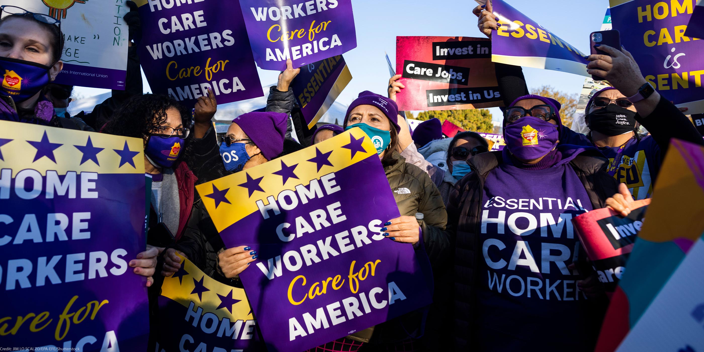 Multiple demonstrators hold up signs that read" "HOME CARE WORKERS CARE FOR AMERICA".