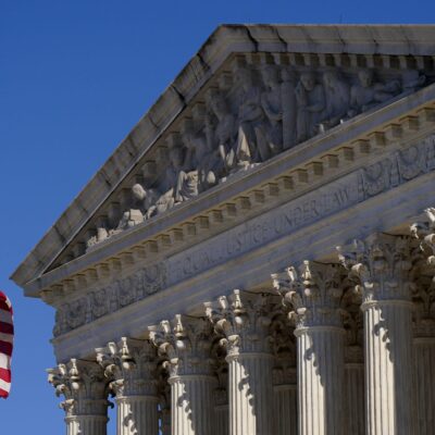 A half-lowered US flag waves in front of the US Supreme Court.